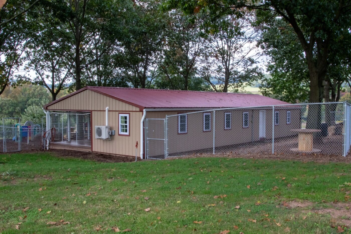 Amber's tan and red metal roofed and trimmed dog boarding facility