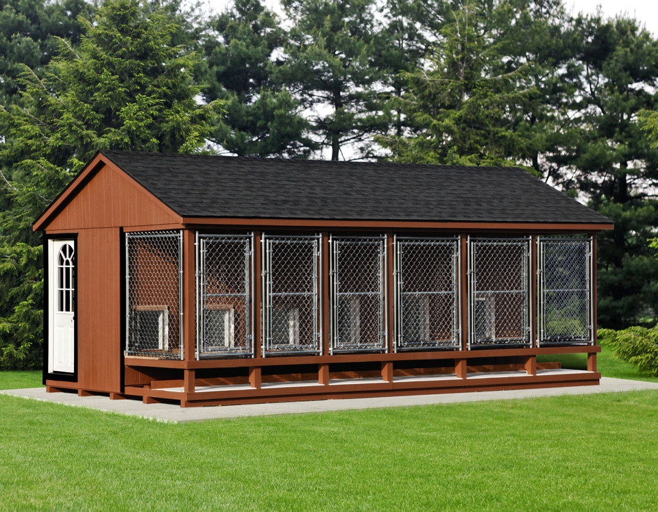 brown commercial dog kennel with shingle roof and multiple attached chain link runs