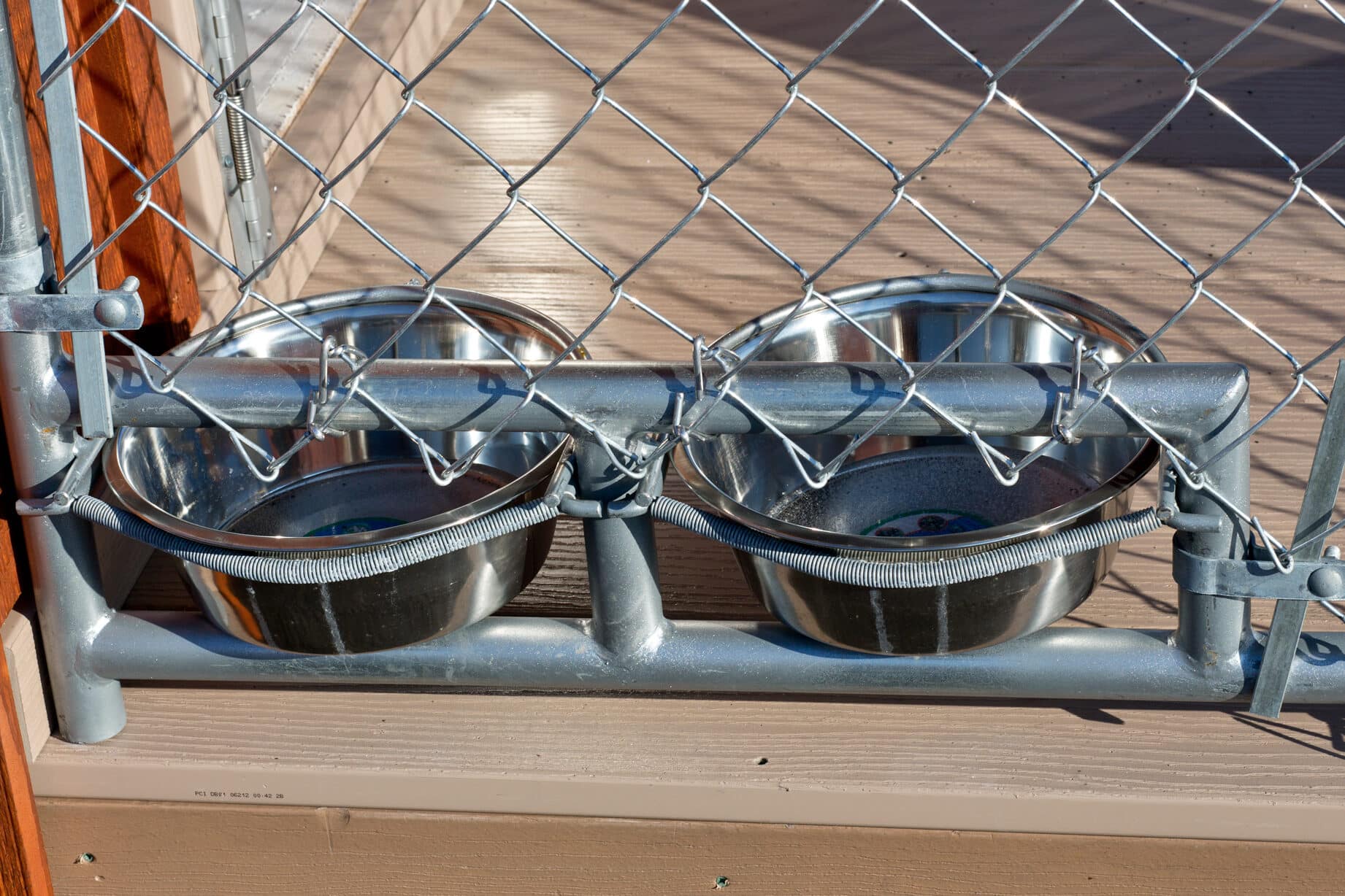 eeder and waterer dishes connected to commercial kennel fencing