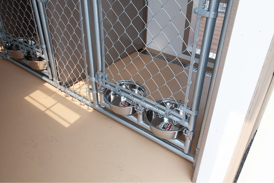 feeding and watering dishes inside dog daycare kennel