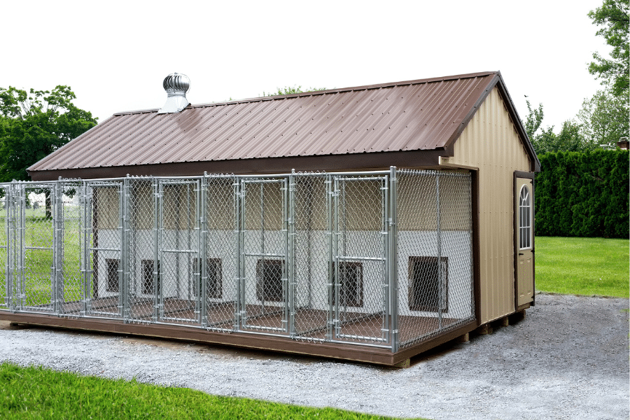 tan metal dog kennel with 6 attached chain link runs and reddish brown metal trim and roofing