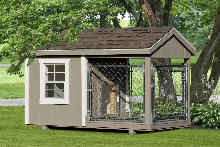 tan outside dog kennel with white trim brown shingle roof and an attached run